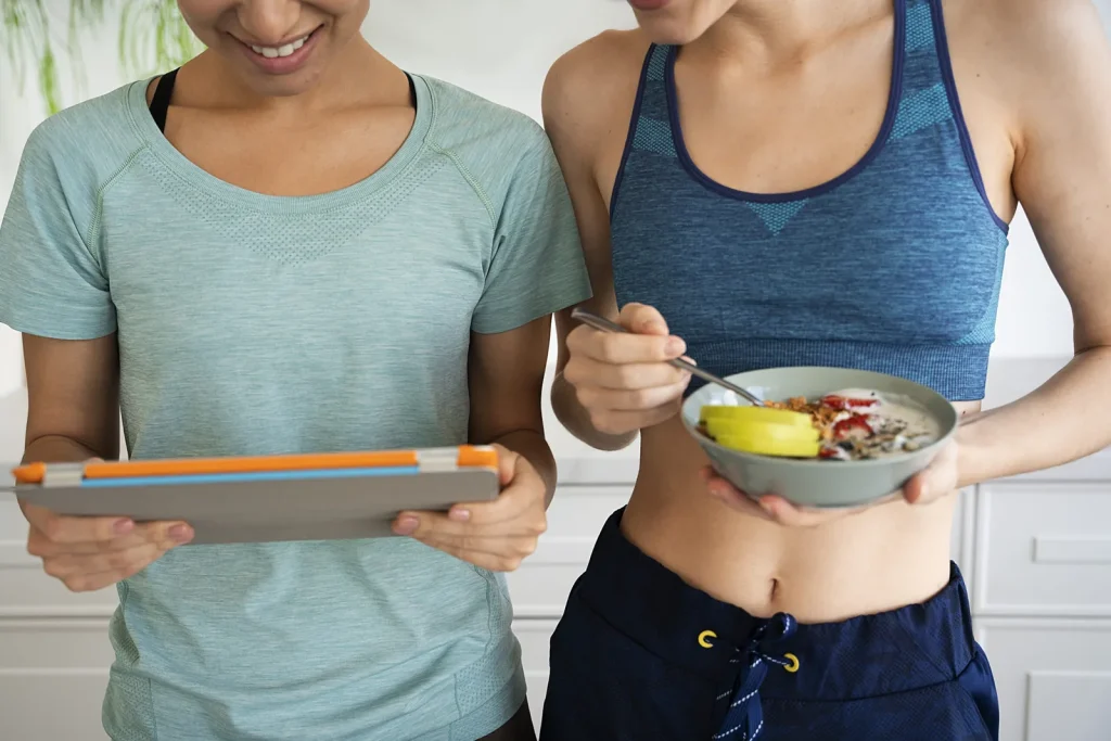 Dos mujeres con una tableta y un bol de comida sana