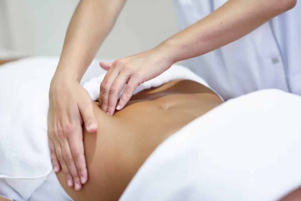 Profesional tratando el abdomen de una paciente