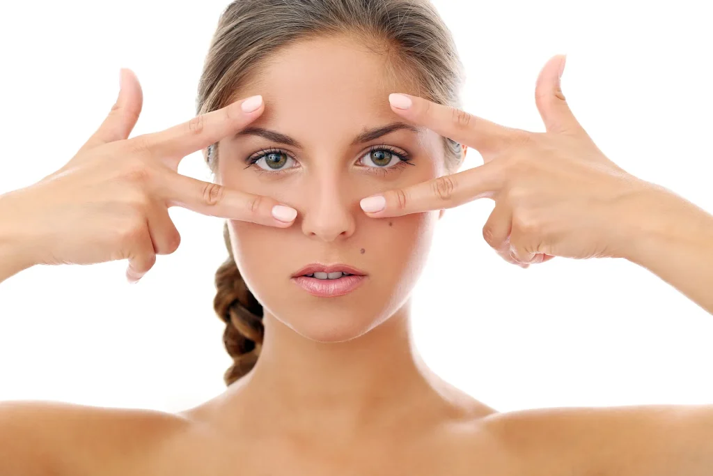 Mujer enmarcando sus ojos con los dedos para mostrar el contorno de ojos rejuvenecido