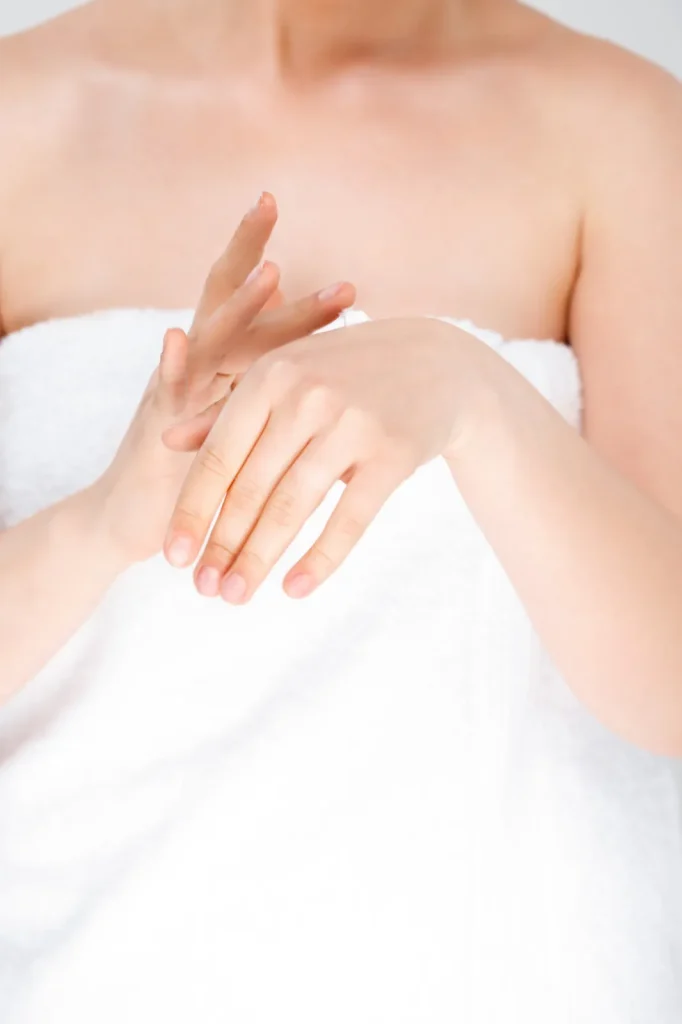 Mujer aplicándose crema en las manos, tratamiento de manos
