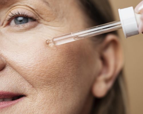 cerrar-mujer-senior-usando-suero-min